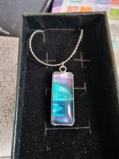 Sterling silver rectangular pendant on sterling silvershiny flat chain, pendant contains muted purple and turquoise artwork