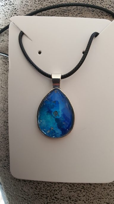 Silver teardrop pendant containing deep blue and silver gilded original art work