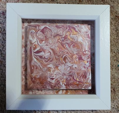 A holiday within Red, white and gold pouring acrylic abstract canvas on matching paper art within white box frame.