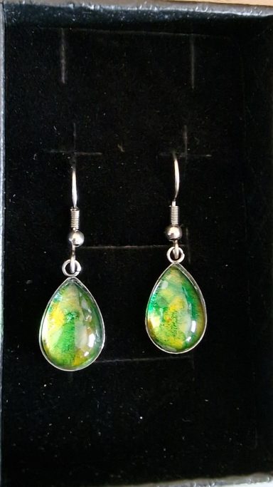Stainless steel teardrop earrings containing parts of original art in green and golds.