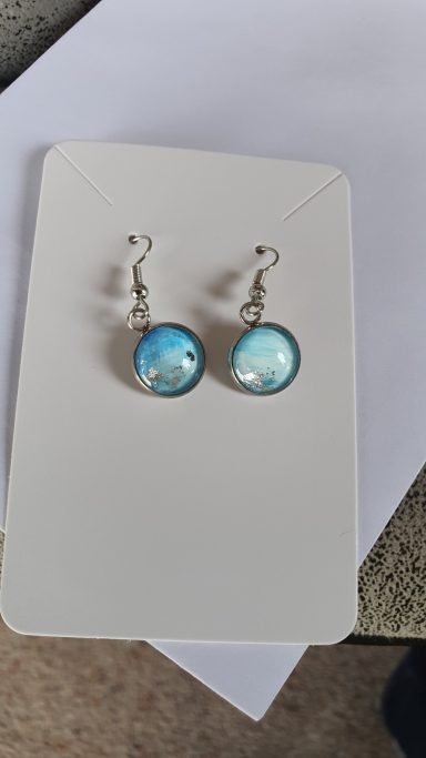 Silver colour round drop earrings containing original light blue and silver gilded artwork