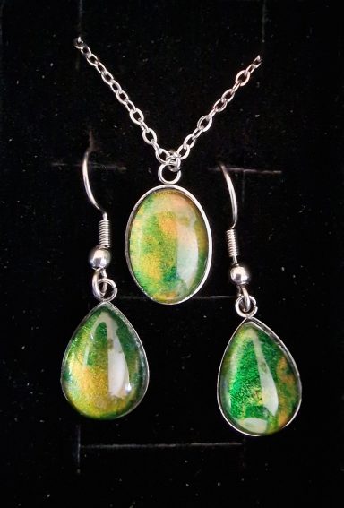 Stainless steel oval pendant and teardrop earrings containing parts of original art in green and golds.
